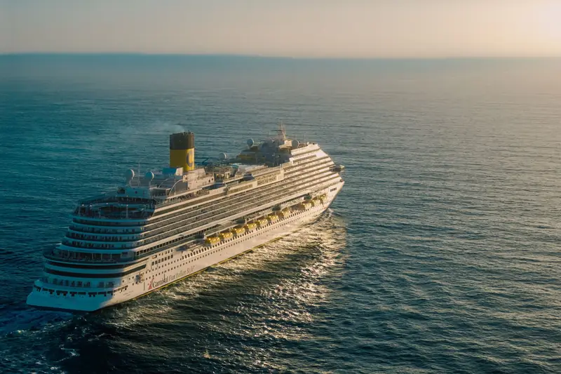 Navio de cruzeiro navegando em mar aberto no fim da tarde